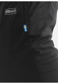 Zwarte jas van gladde stof, met een klein blauw en geel Zweeds vlagpatch en een grijs logo aan de bovenlinkerzijde.