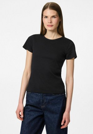 Camiseta negra de manga corta con cuello redondo, de diseño ajustado y textura suave, combinada con jeans de mezclilla oscura.