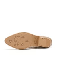Suola di scarpa marrone chiaro con una texture liscia, caratterizzata da un logo in rilievo e motivi a stella. Il tacco è leggermente arrotondato con piccole perforazioni.