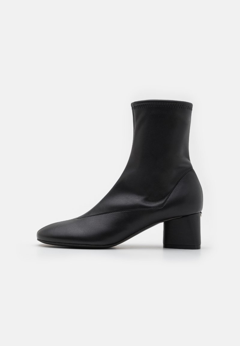 Svart ankelboot med en åtsittande design, tillverkad av slätt läder. Har en fyrkantig klack och minimal sömdekor.