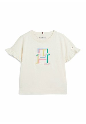 Kremfarvet kortærmet babyshirt med flæser på ærmerne og flerfarvede broderede "TH"-bogstaver centreret på brystet.