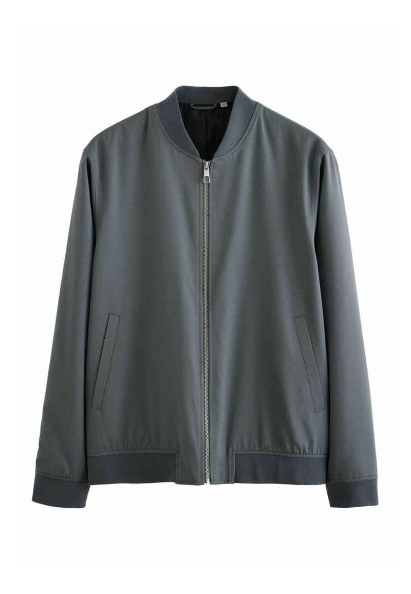 Szary bomber z gładkiego materiału, z zamkiem błyskawicznym, ściągaczami przy mankietach oraz dwoma bocznymi kieszeniami. Minimalistyczny design z klasycznym krojem.