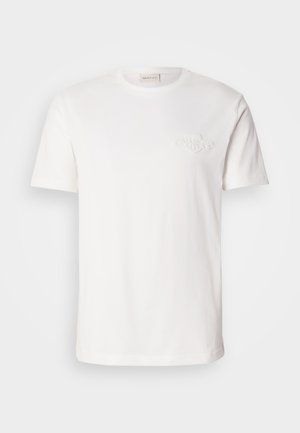 Hvid bomulds t-shirt med korte ærmer, der har et subtilt præget logo på brystet. Klassisk crew neck design, glat tekstur.