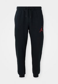 Sorte joggers med elastisk talje og snørrebånd, mansjetterede ankler og lille rød Jumpman-logo på den øvre venstre lår.
