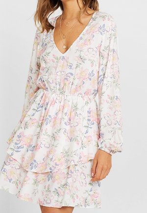 Robe fleurie en tissu léger avec des motifs roses, bleus et verts ; dotée d'un col en V, de manches longues et d'un ourlet à volants superposés.