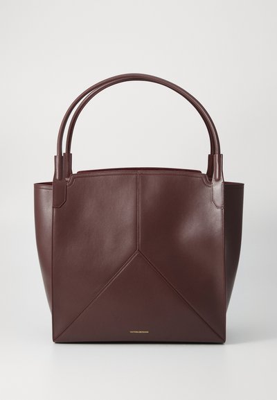 Bordeaux leren tote bag met een geometrisch ontwerp, voorzien van twee stevige handvatten en een gouden logo aan de onderkant.