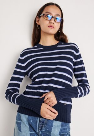 Tamsiai mėlynas ir šviesiai mėlynas dryžuotas megztinis su megztomis apykaklėmis ir kraštu, pasižymintis prigludusiu dizainu ir tekstūruota medžiaga.