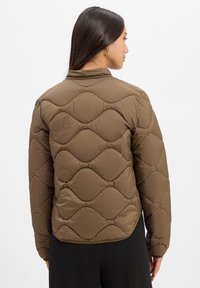 Brown quilted puffer jacket featuring a high collar, smooth texture, and curved diamond pattern across the back.