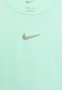 Mintgrön Dri-FIT träningsskjorta i texturerad tyg, med en guldig Nike swoosh-logotyp på övre vänstra bröstet.