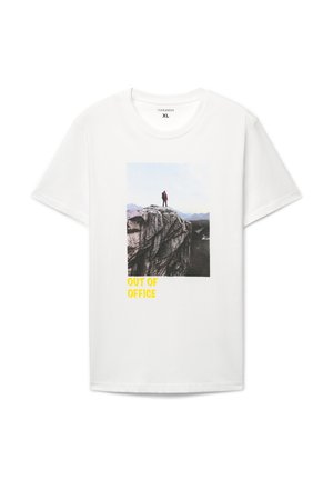 Biała koszulka z krótkim rękawem z grafiką osoby na klifie oraz napisem „OUT OF OFFICE” w żółtym kolorze u dołu.