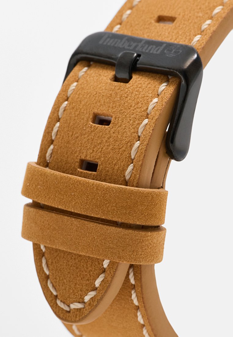 Tania skórzana bransoleta zegarka z czarną metalową klamrą. Posiada kontrastowe przeszycia oraz wiele otworów do regulacji długości.