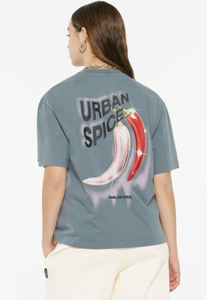 Gray cotton t-shirt featuring a large graphic of red and white chili peppers with the text "URBAN SPICE" below, designed with a relaxed fit.