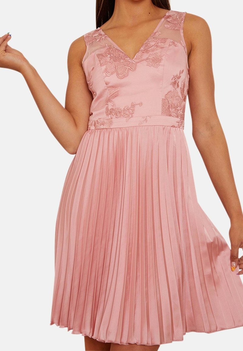 Rosa plisserad klänning med V-ringning, blommig broderi på bodice och ärmlös design. Satinmaterial med en mjuk textur och flöde.