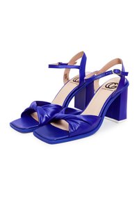 Paar blauwe leren hoge hak sandalen met enkelbandjes, vierkante neuzen, gedraaid voorontwerp en chunky blokhakken.