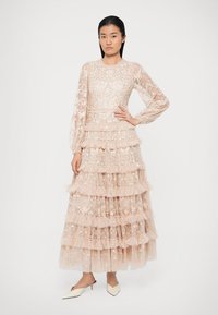 Ilga, daugiasluoksnė suknelė, pagaminta iš subtilaus, permatomo šilko rožių spalvos. Su gūrstelėjimais ir ilgomis permatomomis rankovėmis.