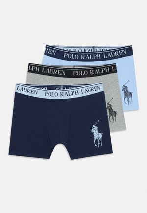 Drie paren mannenboxershorts in navy, grijs en lichtblauw. Elk paar heeft een logo-onderband en het navy paar heeft een graphic van een polo speler.