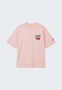 T-shirt rose clair à manches courtes avec deux cerises rouges et le texte « Change the game » imprimé sur la poitrine gauche, ainsi qu’un petit logo noir sur la manche droite.