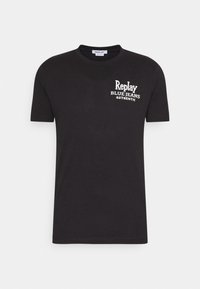 Czarny bawełniany t-shirt z krótkimi rękawami i okrągłym dekoltem. Z przodu widnieje biały nadruk: "Replay BLUE JEANS AUTHENTIC." Gładka faktura.