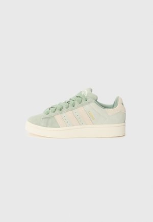 Baskets Adidas Campus en daim vert clair avec des bandes et une semelle crème, montrant le côté extérieur et les lacets sur fond uni.