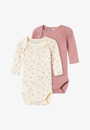 Zwei langärmelige Bodysuits: einer in Creme mit kleinen roten Herzen, der andere in einfarbigem Staubrosé; weiches Baumwollmaterial mit Druckknöpfen am Boden.
