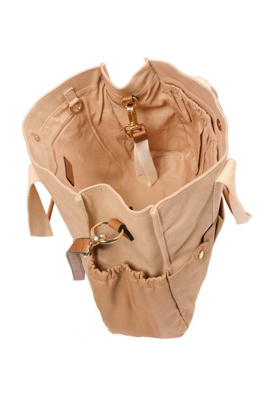 Beige canvas tas met meerdere binnen- en buitenvakken, sluitingen in goudkleur en een sleutelring bevestigd aan een elastisch zijvak.