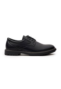 Zapato de vestir de cuero negro con punta redonda, superficie texturizada y cierre de cordones. Presenta una suela de goma duradera con un patrón de tracción.