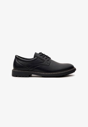 Zapato de vestir de cuero negro con punta redonda, superficie texturizada y cierre de cordones. Presenta una suela de goma duradera con un patrón de tracción.