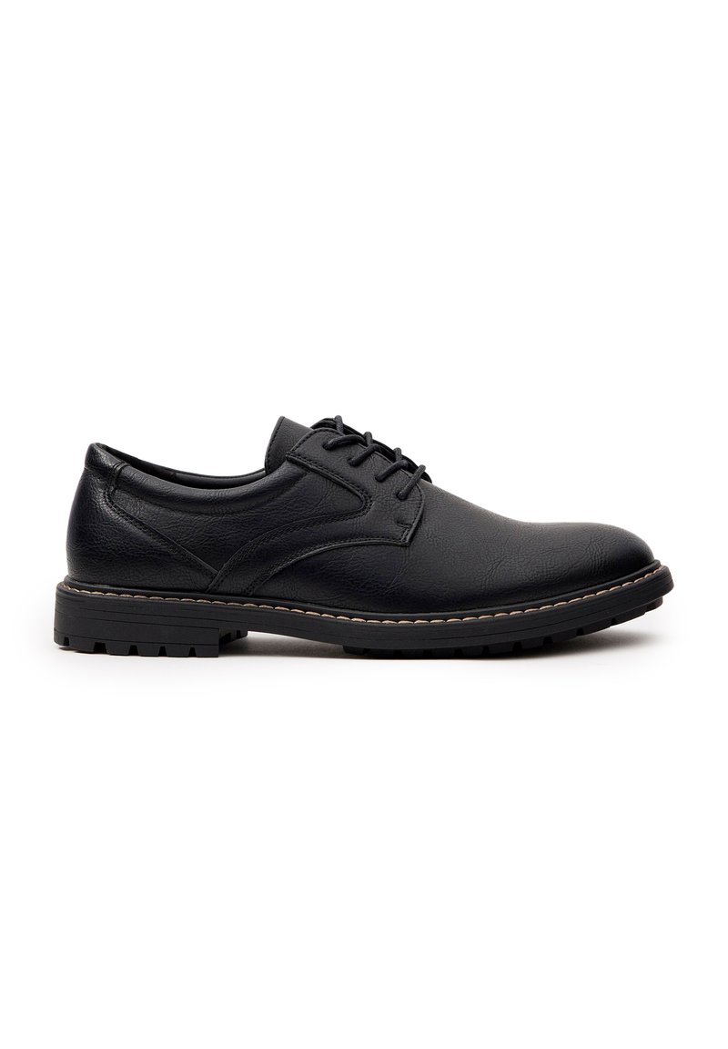 Zapato de vestir de cuero negro con punta redonda, superficie texturizada y cierre de cordones. Presenta una suela de goma duradera con un patrón de tracción.