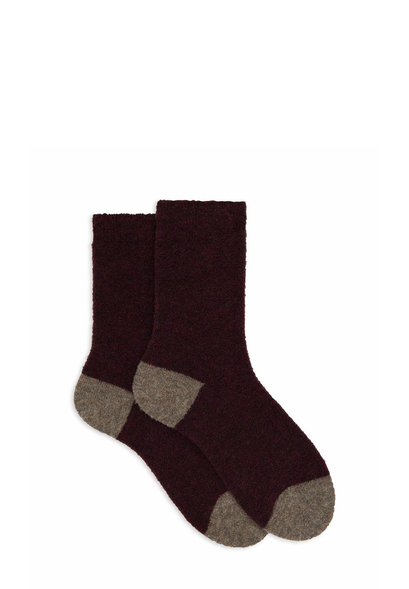 Calzini bordeaux dalla texture morbida con tacco e punta in marrone chiaro a contrasto. Hanno una lunghezza fino a metà polpaccio e un design senza cuciture.