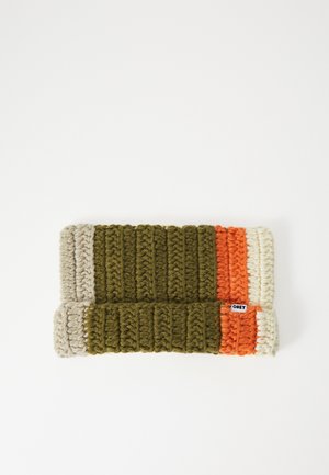 Écharpe en grosse maille pliée en vert olive, orange et beige avec une texture côtelée et une petite étiquette "OBEY" sur une bande orange.