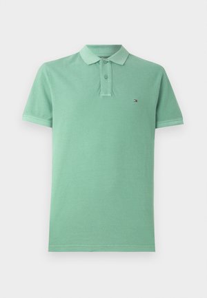 Polo vert en coton, avec un col classique, une patte de boutonnage à deux boutons et un petit logo sur la poitrine. Manches courtes.