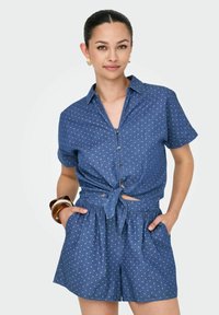 Jeansromper med korta ärmar, knäppning och knuten detalj framtill. Ljusblå med vita prickar och elastisk midja; fickor ingår.