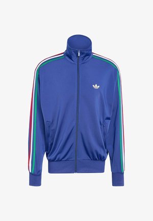 Blauwe zip-up trainingsjack van gladde stof, met groene, rode en witte strepen langs de mouwen en een klein wit logo op de borst.