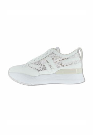 Sneaker bianca con pannelli in pizzo floreale, suola spessa, chiusura frontale con lacci e tirante sul tallone, mostrata di profilo su sfondo bianco.