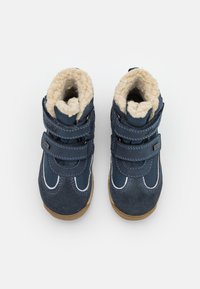 Botas de invierno azul marino con correas de velcro, materiales de ante y malla, costuras blancas, forro de felpa acogedor y una suela de goma marrón.
