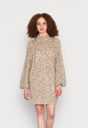 Vestido de malha em bege, com um padrão texturizado, gola alta e mangas balão soltas, com manchas de preto e castanho.