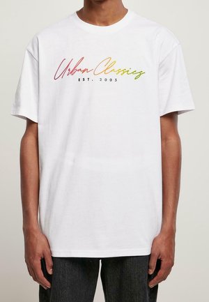 White cotton t-shirt featuring multicolored "Urban Classics" text and "EST. 2005" in contrasting black, with a relaxed fit and short sleeves.