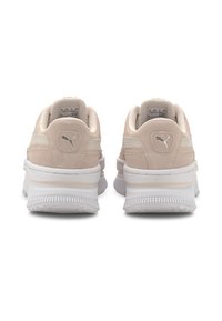 Baskets en daim beige avec semelles en caoutchouc blanc, présentant un design subtil, des accents texturés et un petit logo sur le talon.