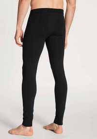 Zwarte leggings gemaakt van rekbare stof, met een gladde textuur, een aansluitend ontwerp en een elastische tailleband. Geen zichtbare patronen of hardware.