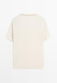 Korte ærmer T-shirt i creme med rund hals og kontraststing. Blødt, let stof med en glat tekstur.