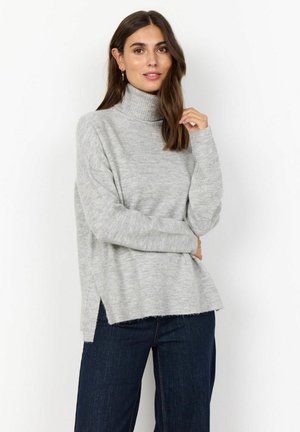 Lys grå turtleneck sweater med en afslappet pasform, ribbede manchetter, sideslids og en blød tekstur. Matchet med mørkeblå brede ben jeans.