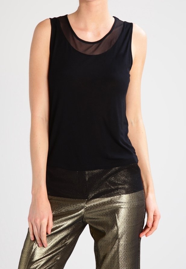 Top negro sin mangas con un escote transparente, combinado con pantalones metálicos dorados texturizados, creando un contraste en materiales y acabados.