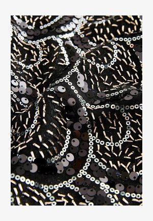 Svart tyg prytt med glänsande, runda paljetter och metalliska pärlor i vågiga mönster. Texturen ser slät ut med intrikata detaljer.