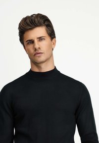 Czarny, lekki, prążkowany sweter typu golf z dopasowanym krojem. Posiada wysoki kołnierz i długie rękawy, wykonany z gładkiej dzianiny.