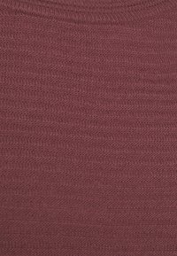 Laivastonsininen neulottu kangas, jossa on teksturoitu, ribbineulottu kuvio. Pinta näyttää vaakasuoria viivoja, mikä luo hienovaraisen kudotun vaikutelman.