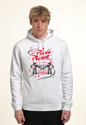 Junger Mann trägt weißen Kapuzenpullover mit rotem und schwarzem "Pizza Planet"-Grafik, die zwei Roboter zeigt, die Pizza vor einem weltraum-themed Hintergrund halten.