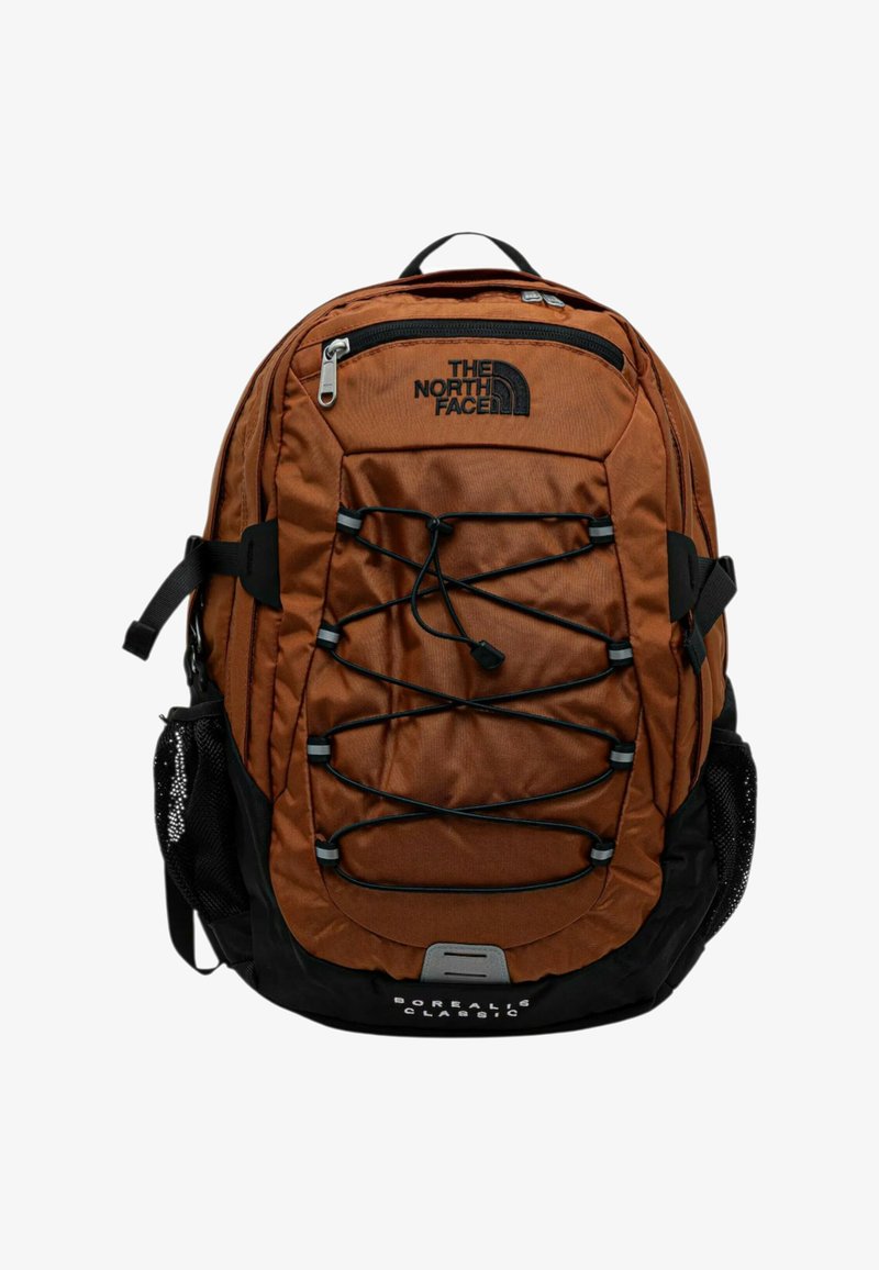 Brązowy plecak z czarnymi akcentami, wykonany z nylonu, z przednim bungee, siateczkowymi bocznymi kieszeniami oraz wieloma suwakami do przegródek.
