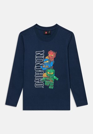 Chemise à manches longues bleu marine avec des personnages LEGO Ninjago en rouge, bleu et vert et le mot NINJAGO en lettres blanches.