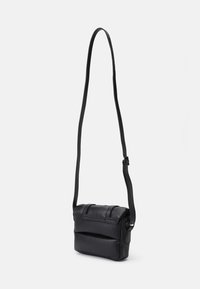 Borsa a tracolla nera in pelle con tracolla regolabile e chiusura a bavero, mostrata su uno sfondo chiaro e semplice.