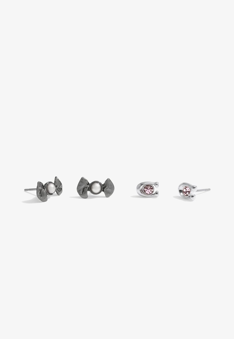 Deux paires de boucles d'oreilles clous en argent : l'une avec un centre en perle blanche et des bords en forme de nœud, l'autre avec une petite pierre précieuse rose dans un sertissage en forme de fer à cheval.